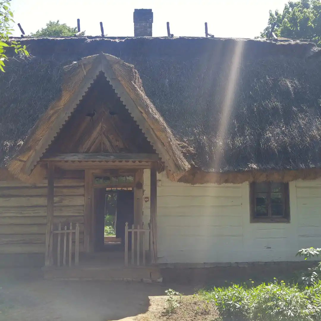 Traditional thatched-roof cottage in a Polish village, representing the family roots of Restaurant Relax